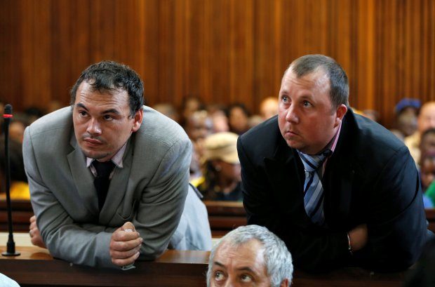 Farmers Willem Oosthuizen and Theo Martins (R) look on during their court appearance as they face sentencing in connection with forcing Victor Mlotshwa into a coffin, threatening to douse him in petrol and burning him alive, at the Middelburg High Court in Mpumalanga province, South Africa, October 23, 2017. REUTERS/Siphiwe Sibeko