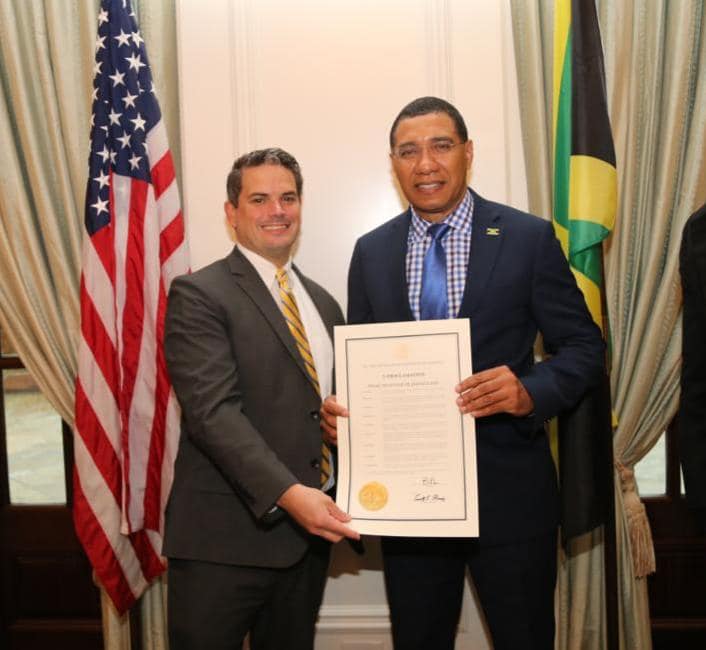 Mr. Daryl Moody who represented the Governor presenting the proclamation to Prime Minister Andrew Holness