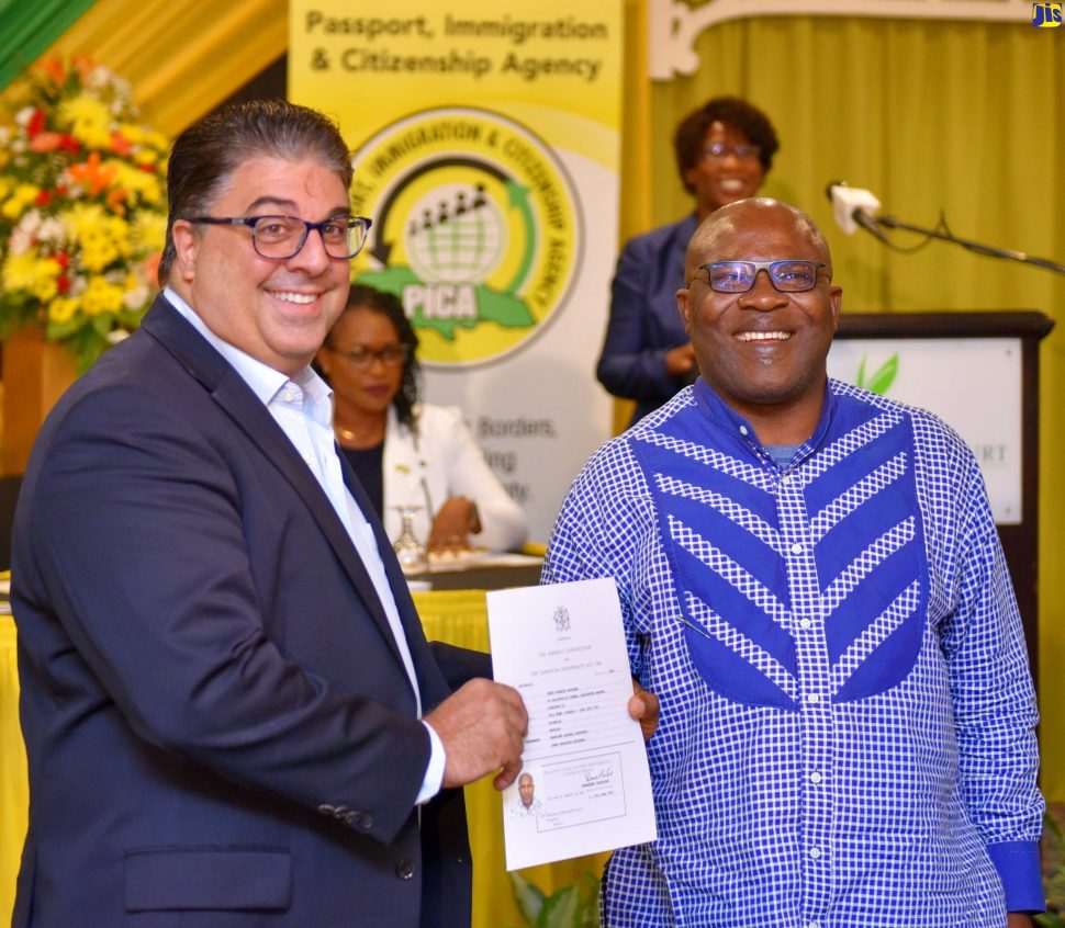Passport, Immigration and Citizenship Agency (PICA) Advisory Board Chairman, Joseph Issa (left), presents Jerry Bayeshea with his citizenship certificate. The presentation was made during PICA’s fourth citizenship swearing-in ceremony at The Knutsford Court Hotel in New Kingston, on Thursday (June 27).