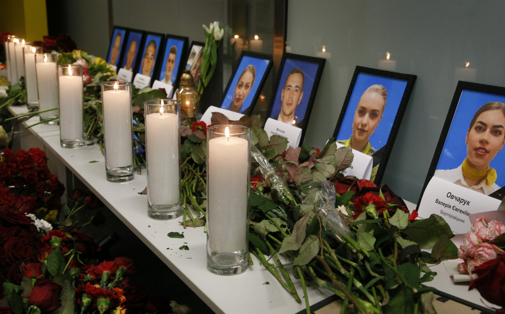 Flowers and candles are placed in front of portraits of the flight crew members of the Ukrainian 737-800 plane that crashed on the outskirts of Tehran, at a memorial inside Borispil international airport outside Kyiv, Ukraine, Wednesday, Jan. 8, 2020. A Ukrainian airplane carrying 176 people crashed on Wednesday shortly after takeoff from Tehran's main airport, killing all onboard, Iranian state TV and officials in Ukraine said. (AP Photo/Efrem Lukatsky)