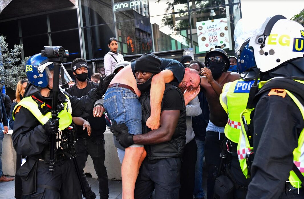 A protester carries an injured counter-protester to safety, near the Waterloo station during a Black Lives Matter protest following the death of George Floyd in Minneapolis police custody, in London, Britain, June 13, 2020. REUTERS/Dylan Martinez