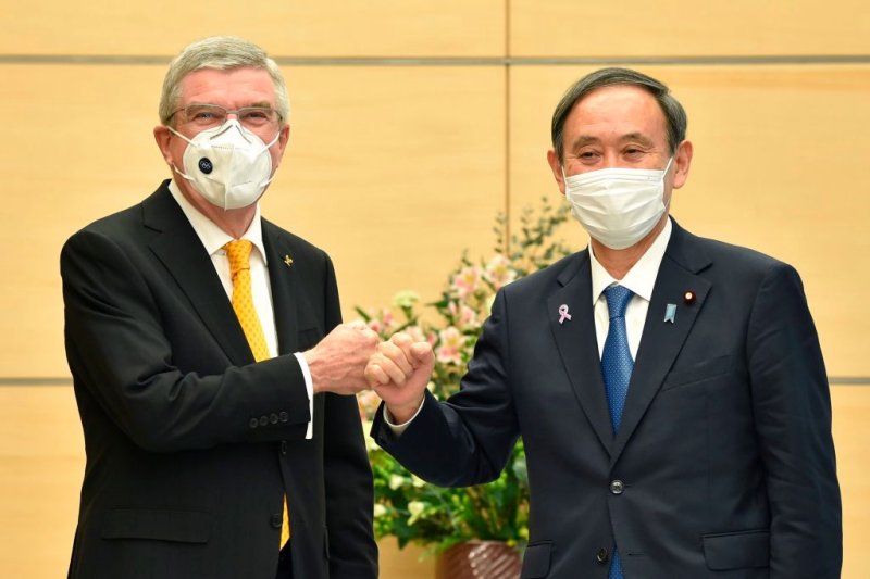 Japan's Prime Minister Yoshihide Suga (R) greets International Olympic Committee (IOC) president Thomas Bach (L) during their meeting in Tokyo on November 16, 2020. (Photo by Kazuhiro NOGI / POOL / AFP) (Photo by KAZUHIRO NOGI/POOL/AFP via Getty Images)